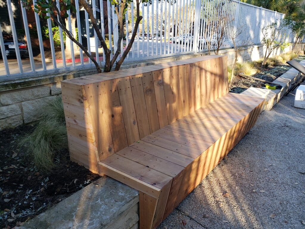 Cedar planters and bench seating beside a pool fence