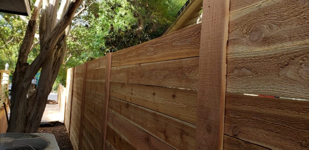 Cedar fence under a shade tree