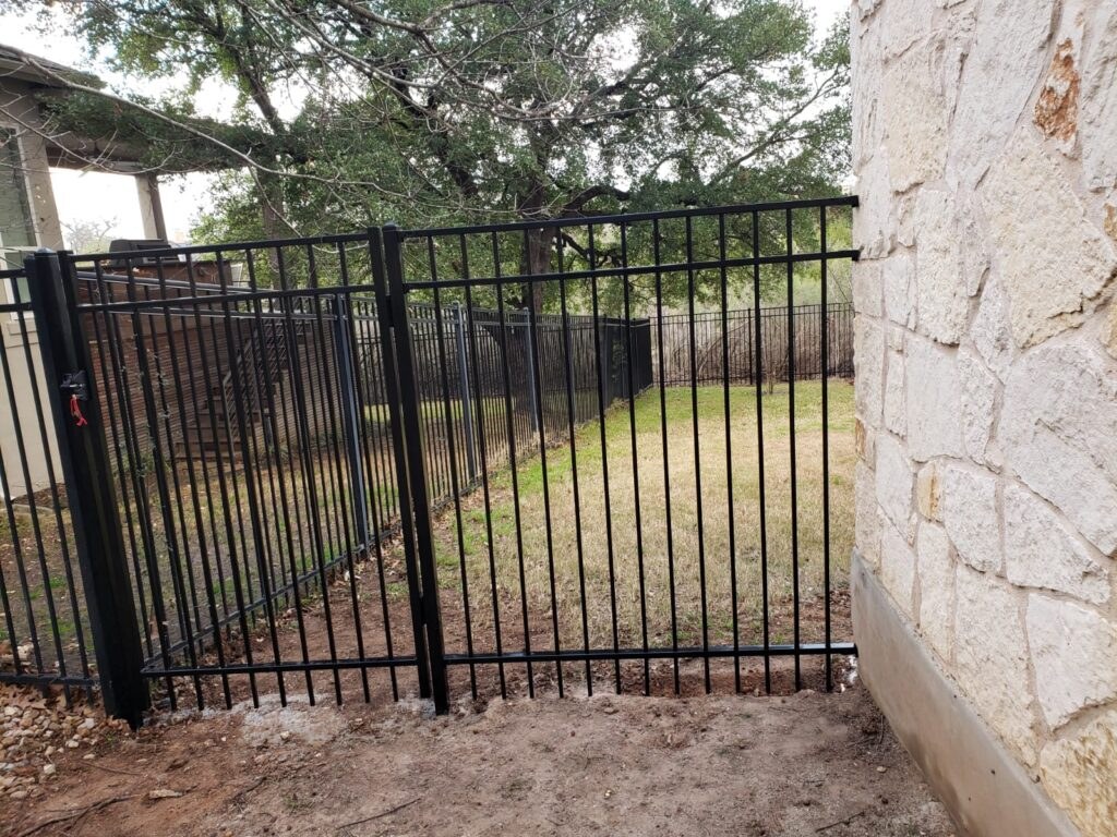 Black iron fence beside a stone home