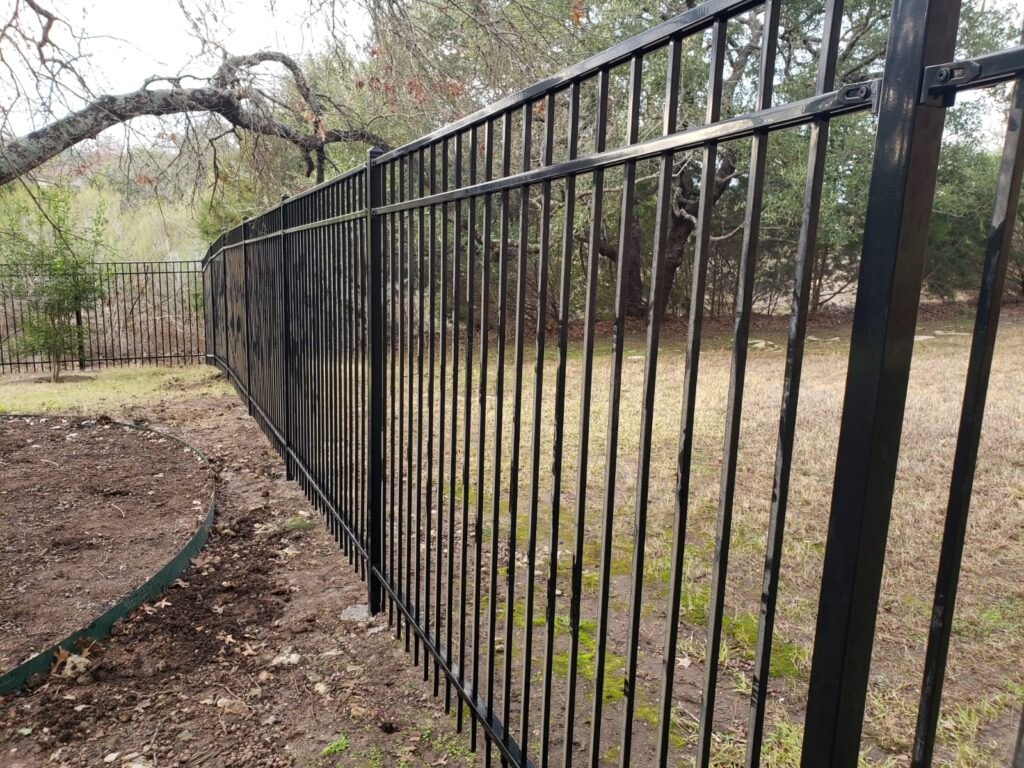 Black ornamental iron fence running along a property