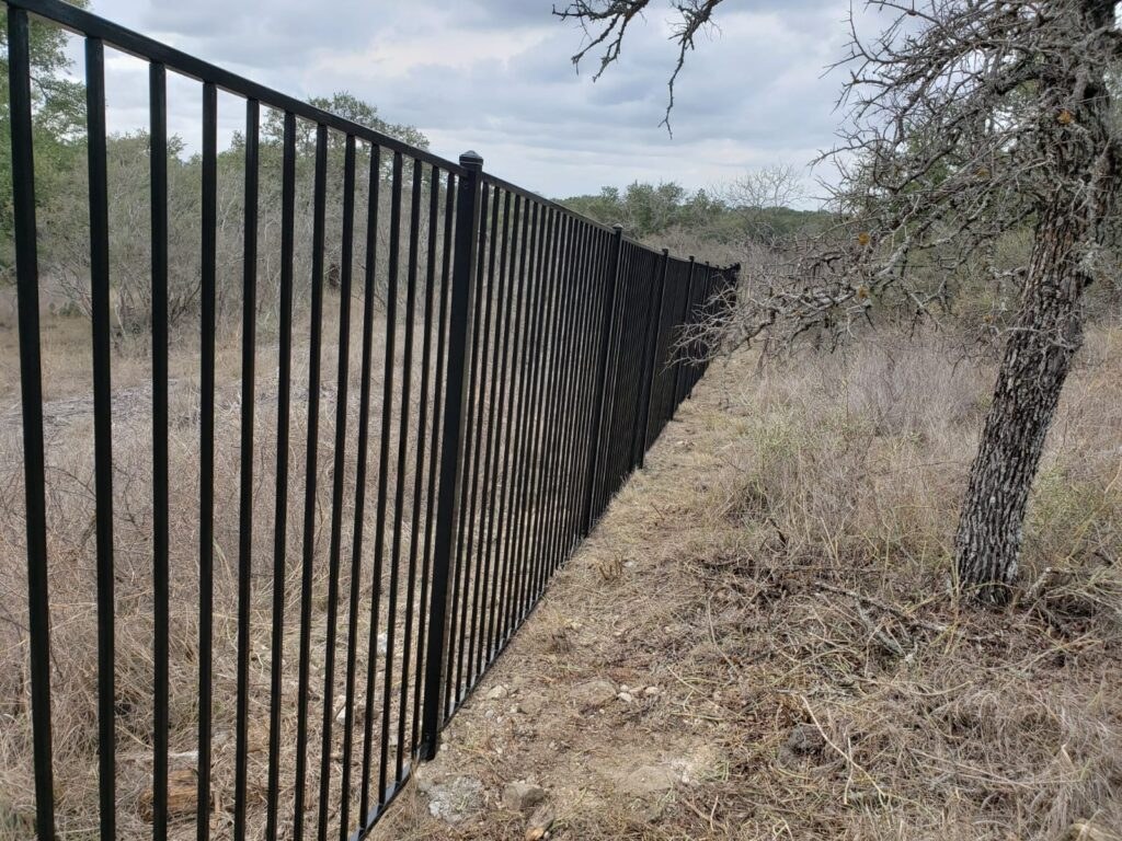 Black iron fence running across open ground