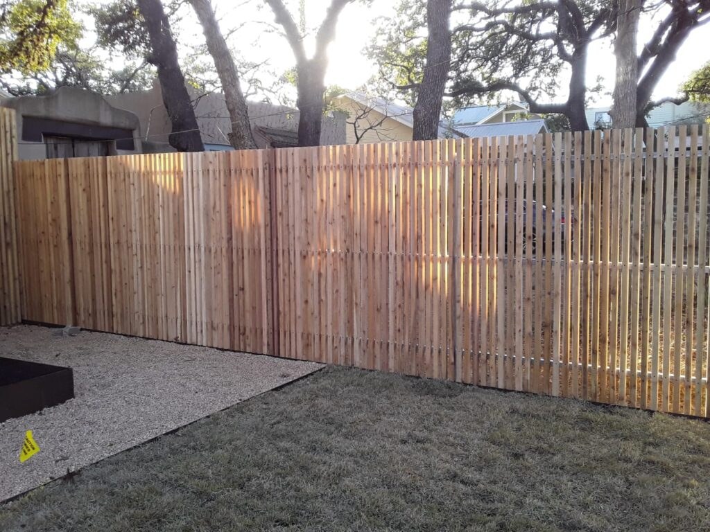 Light cedar picket fence beside a patio