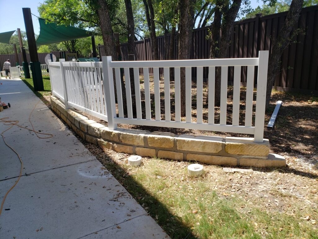White picket-style fence along a sidewalk