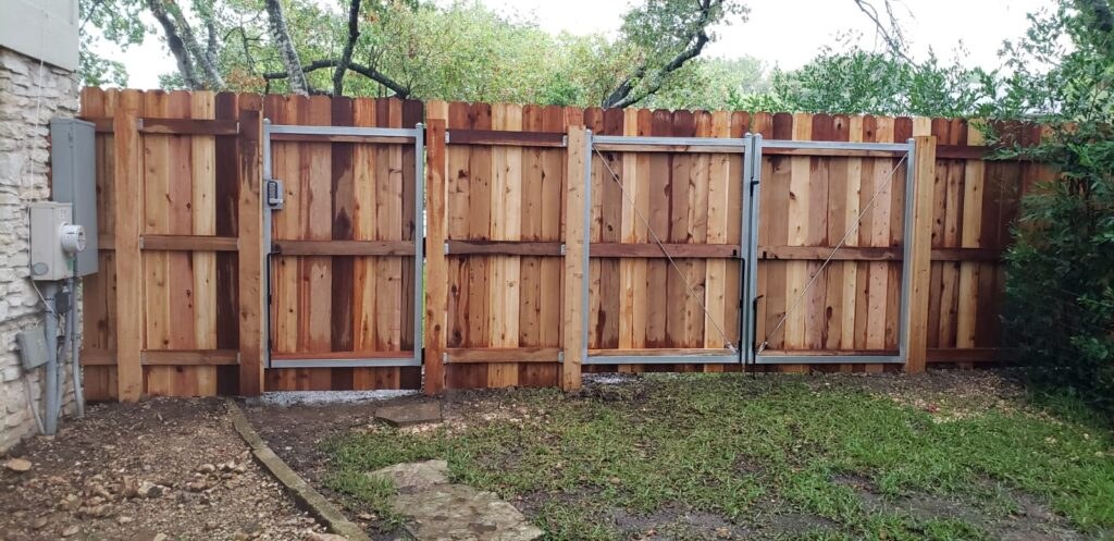 Panel fence running alongside a house and yard
